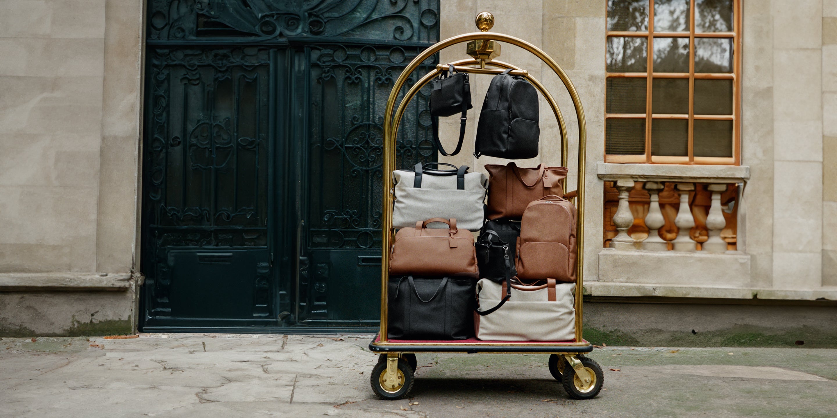 Collection of travel bags on a hotel luggage trolley.