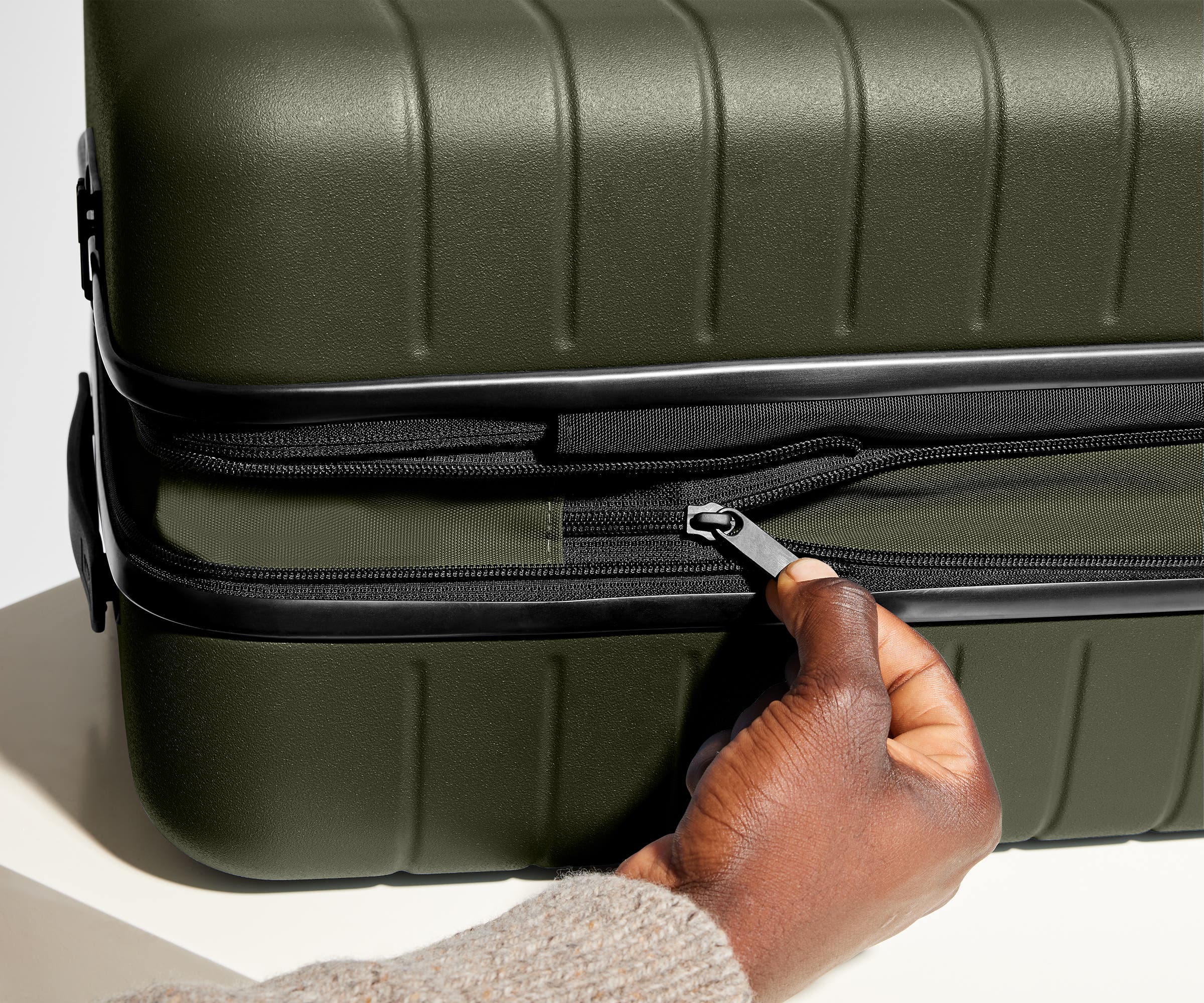 The Bigger Carry-On Flex suitcase in Olive Green has an additional wraparound zipper to expand the suitcase 2.25" (6 cm) and increase packing space