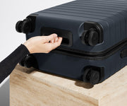 The Carry-On suitcase in Navy Blue shown from below highlighting the underside grab handle