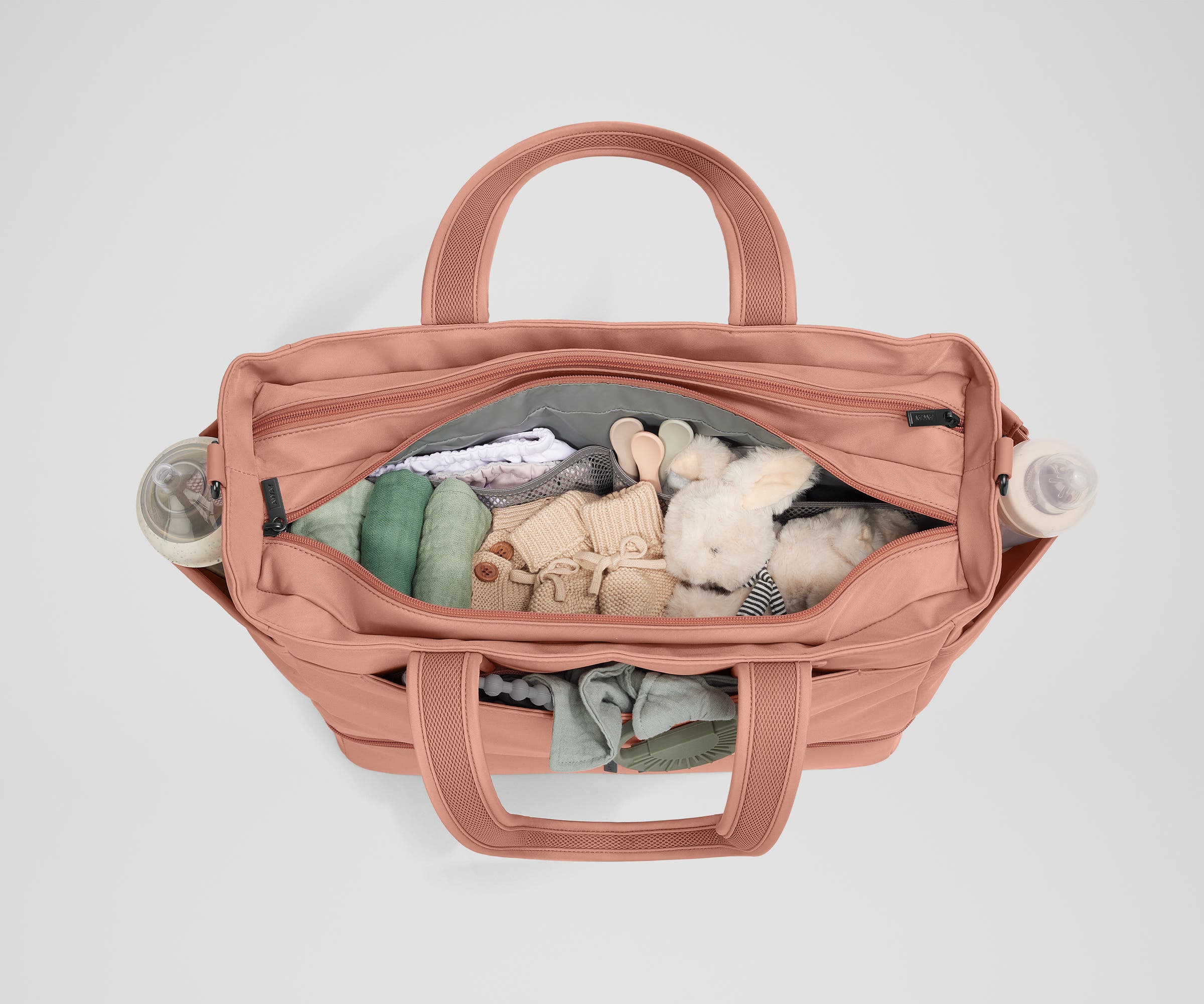 Front main compartment packed with child essentials, including a stuffed animal, wipes, and change of clothes