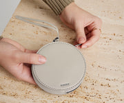 Person's hand holding the Circle Zip Pouch