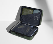 The Carry-On suitcase in Olive Green shown open on its side and packed with Away's packing organizers to show capacity and the interior compression system, designed to help you pack more in