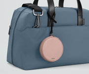 The Circle Zip Pouch looped onto the strap of The Everywhere Bag