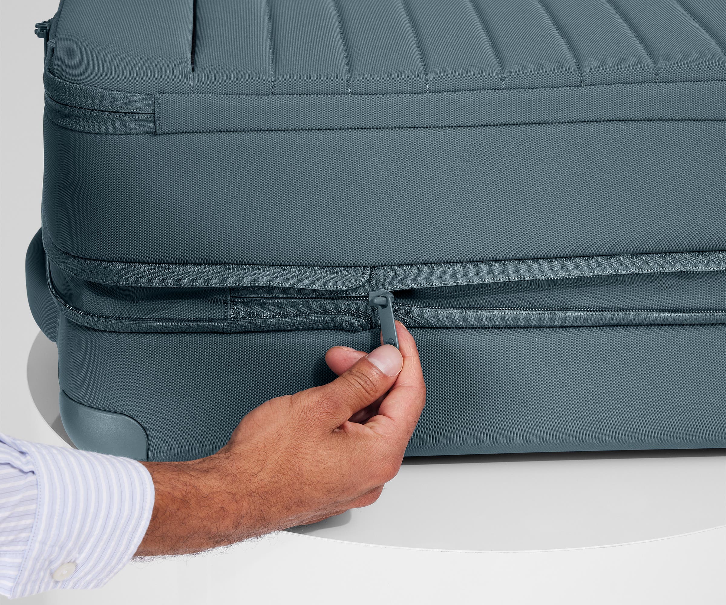 Person expanding the bag, using the wraparound zipper