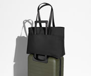 Everywhere Tote secured to an Away suitcase by its trolley sleeve