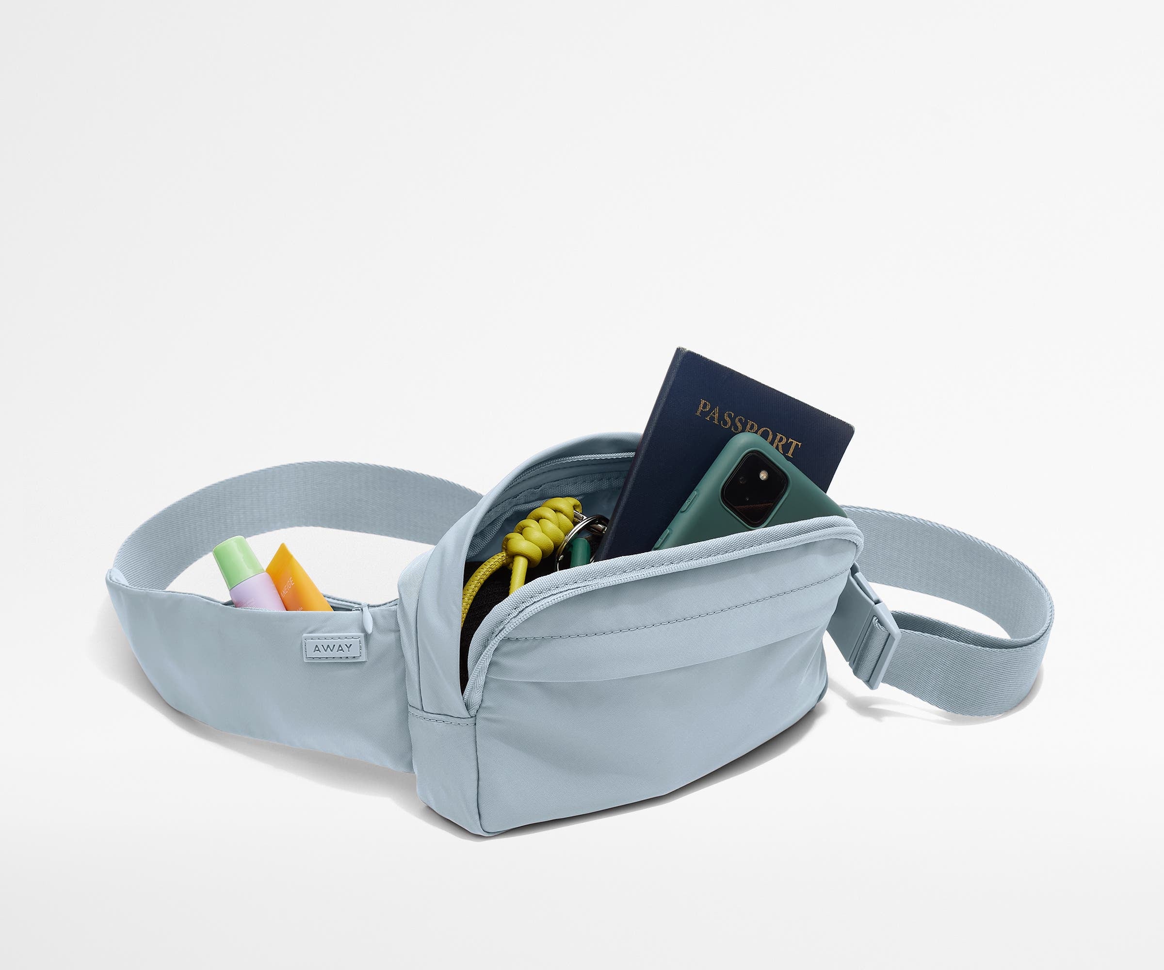 Sling Bag packed with a phone, passport, keys, and chapstick