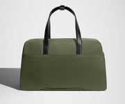 Green weekender bag with black handles on a light gray background