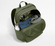 Green backpack with items like a bottle, mask, and headphones on a light gray background