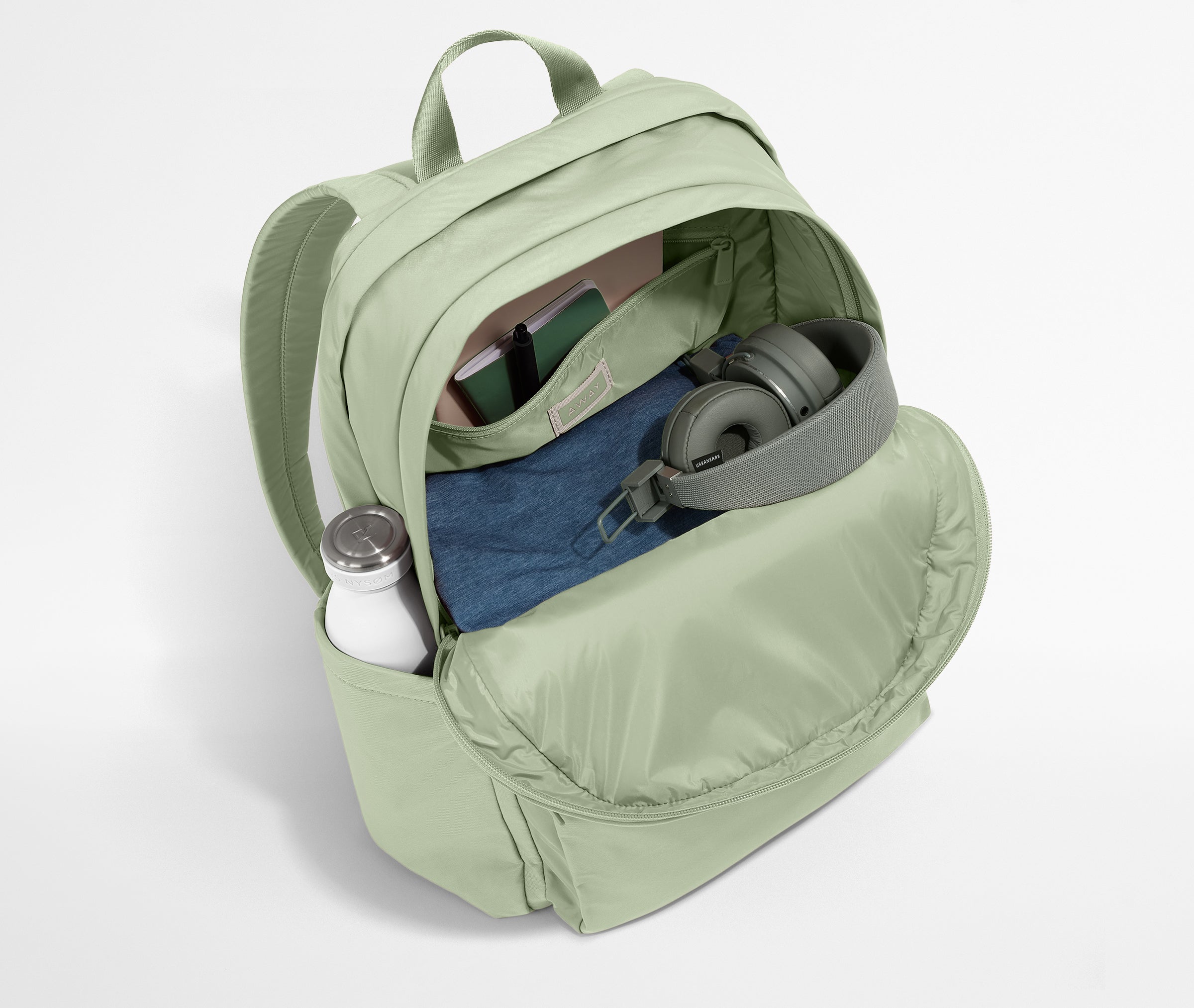 Front compartment packed with a notebooks, headphones, and clothing