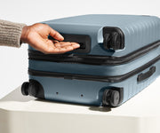 The Carry-On Flex suitcase in Coast Blue shown from below highlighting the underside grab handle
