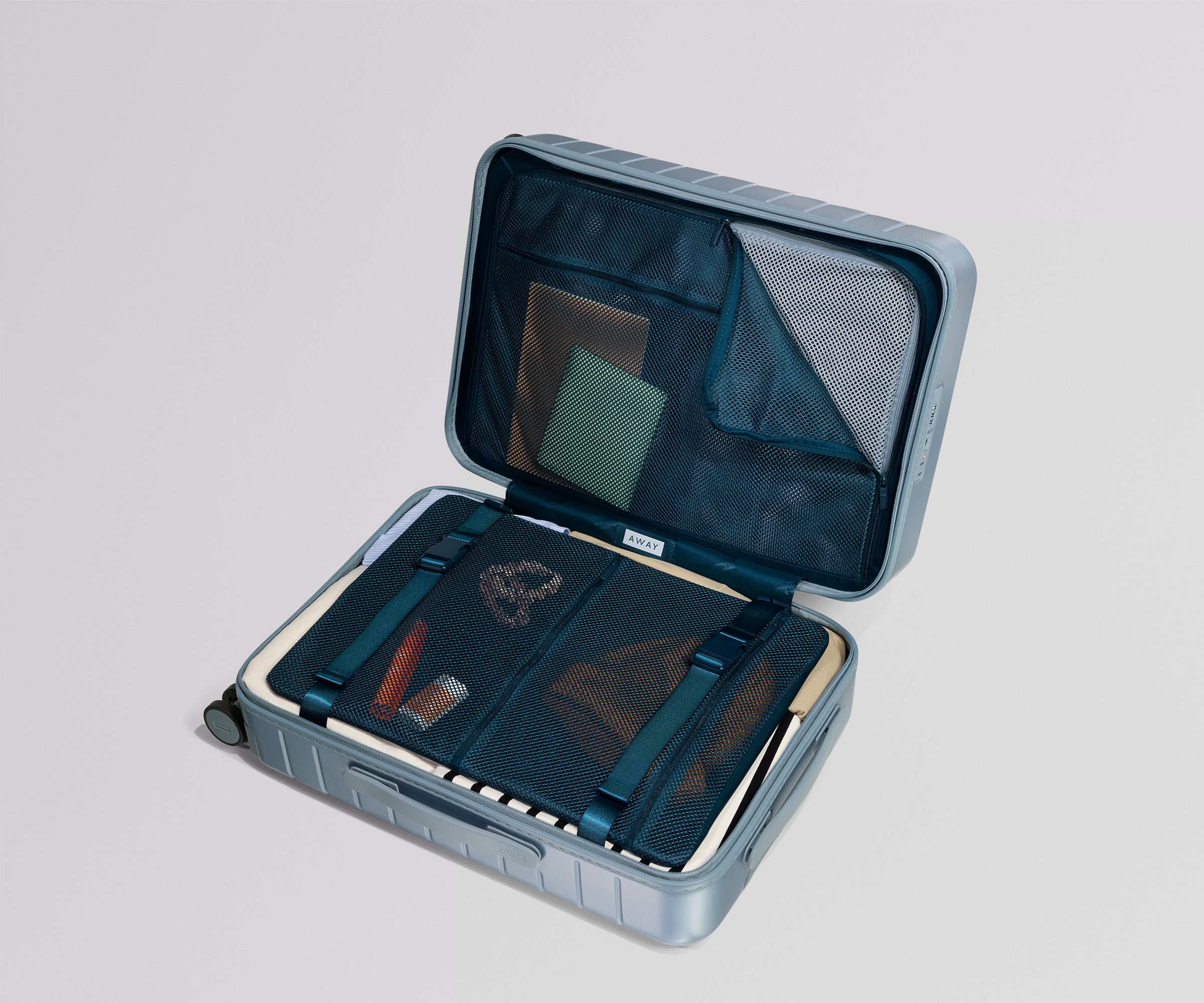 Open blue suitcase with organized compartments on a light gray background