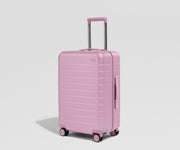 Pink suitcase on a light gray background