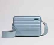 Light blue crossbody bag with a strap on a light gray background