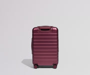 Maroon suitcase on a light gray background