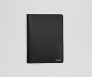 Black leather passport holder with 'AWAY' branding on a light gray background
