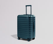 Teal suitcase on a light gray background