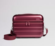 Red travel case with a strap on a light gray background