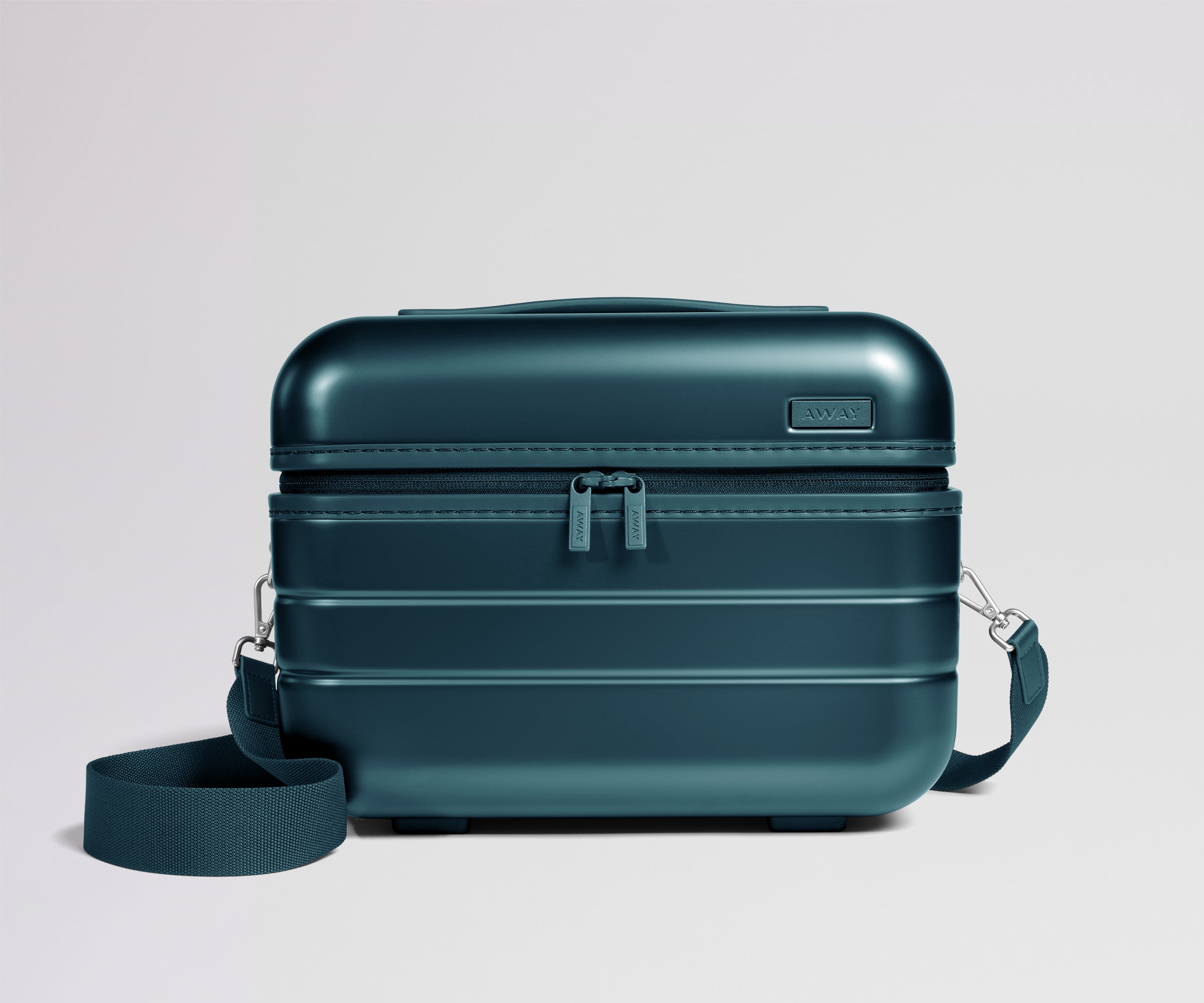 Teal travel case with a strap on a light gray background