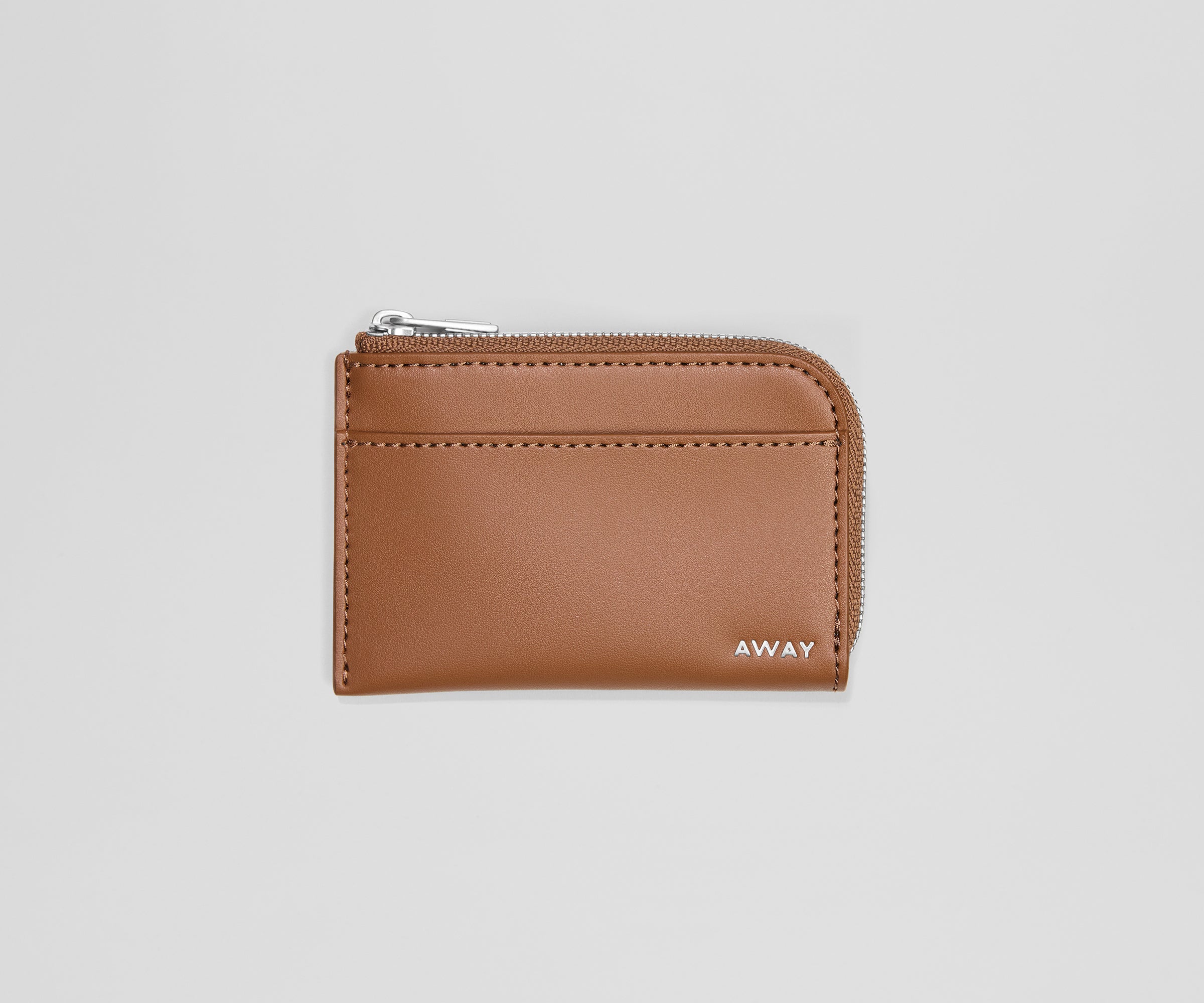 Brown leather cardholder with 'AWAY' branding on a light gray background