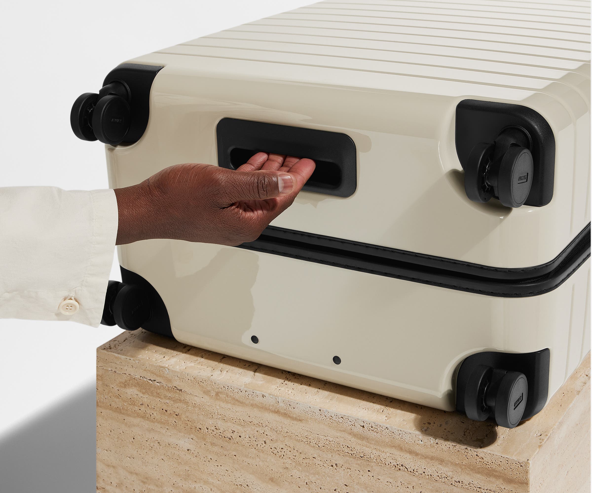 The Medium suitcase in Salt White (Gloss) shown from below highlighting the underside grab handle