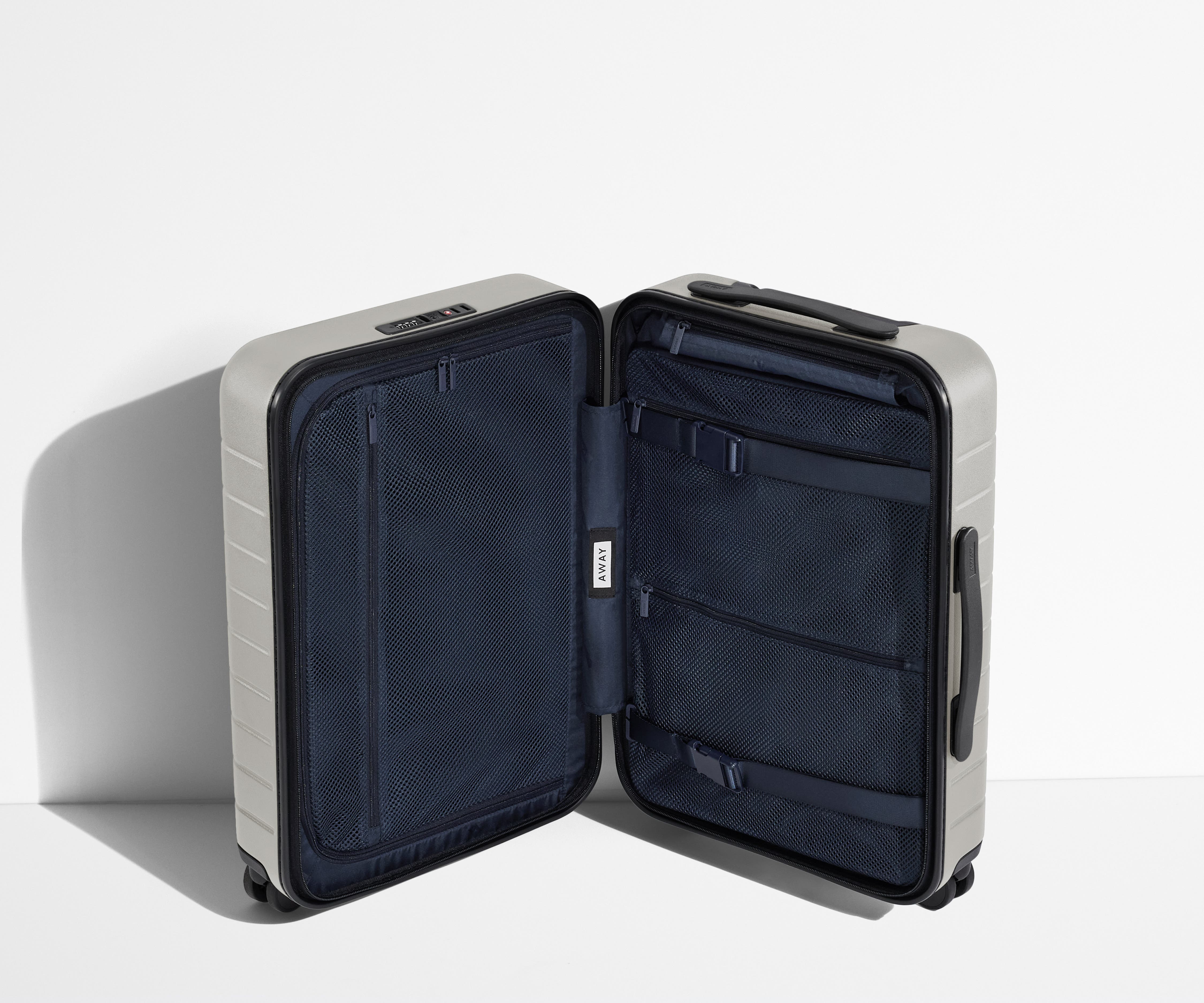 The Carry-On suitcase in Cloud Gray shown open in an upright position to show interior organization and compression system