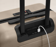 USB charger battery in a Hardside Suitcase with a UB cable plugged in.
