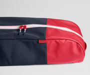 Black and red travel ski bag with 'AWAY' branding on a light gray background