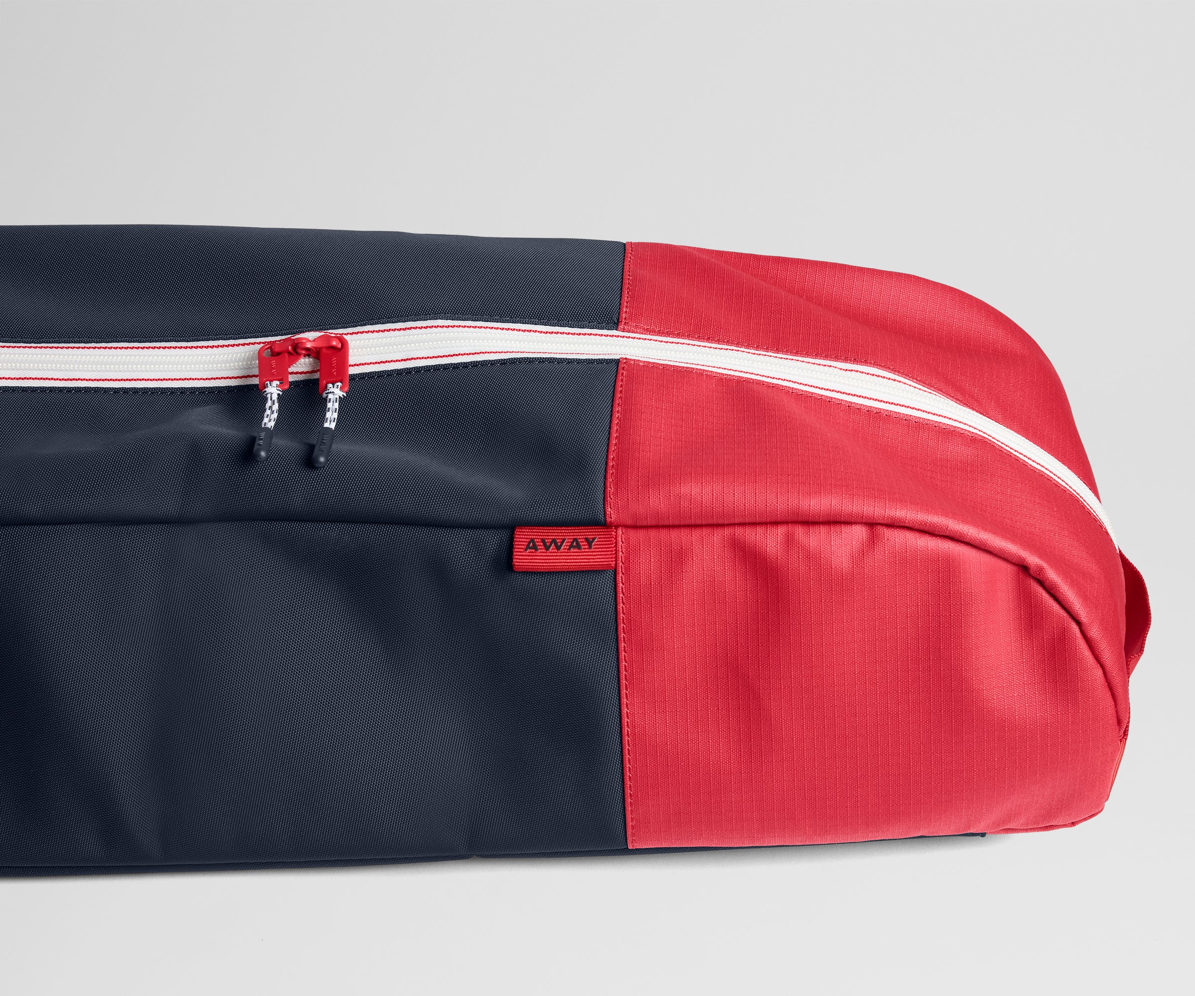 Black and red travel ski bag with 'AWAY' branding on a light gray background