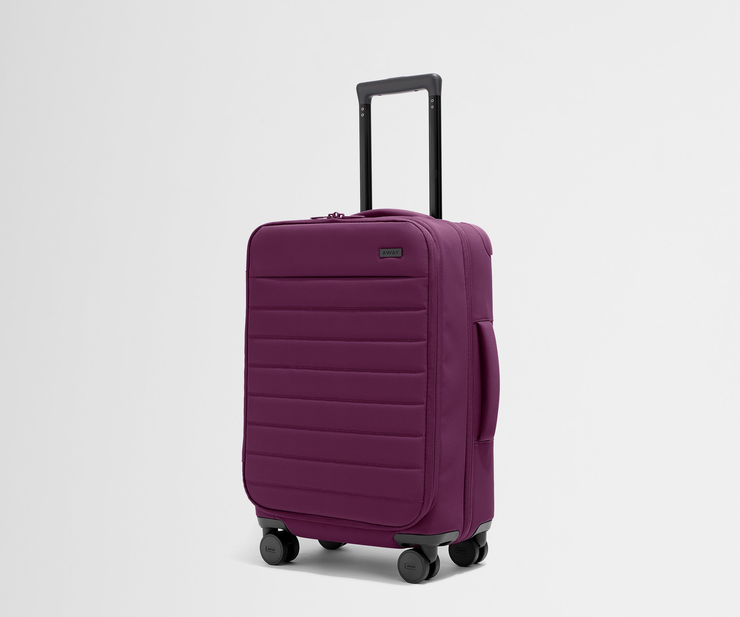 Angled product view of The Softside Carry-On suitcase in Plum Purple with raised handle