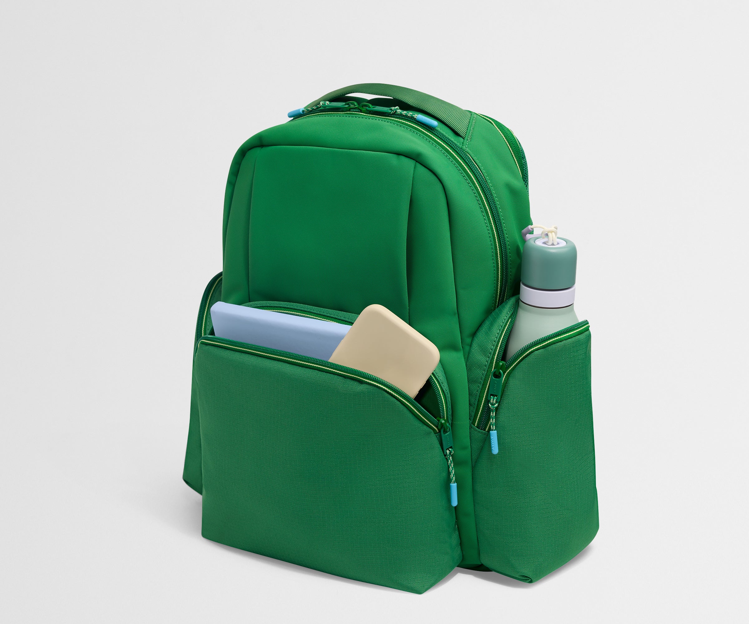 Green backpack with compartments on a light gray background
