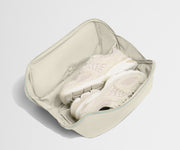 Beige shoe organizer with white sneakers inside on a light gray background