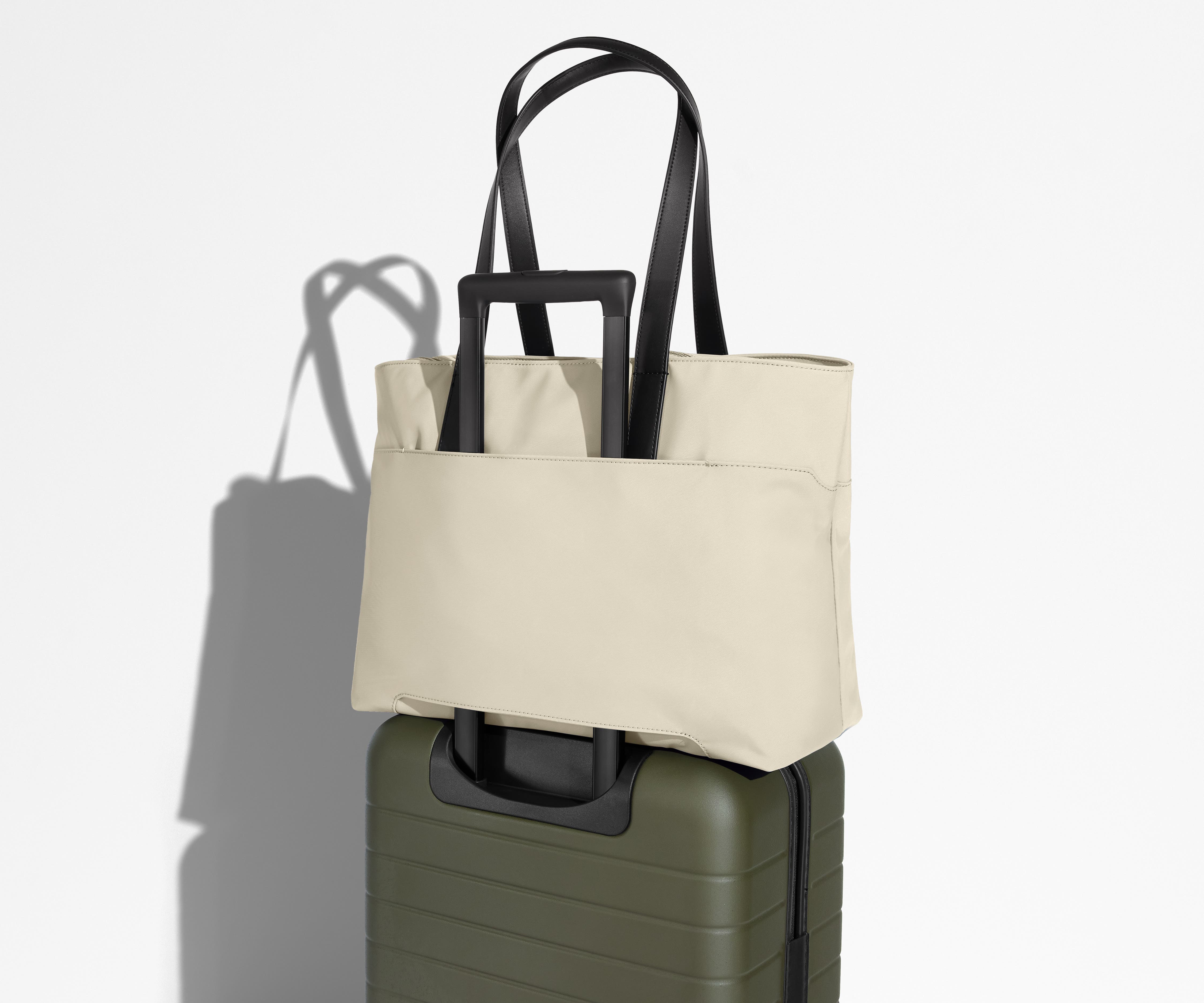 Everywhere Tote secured to an Away suitcase by its trolley sleeve