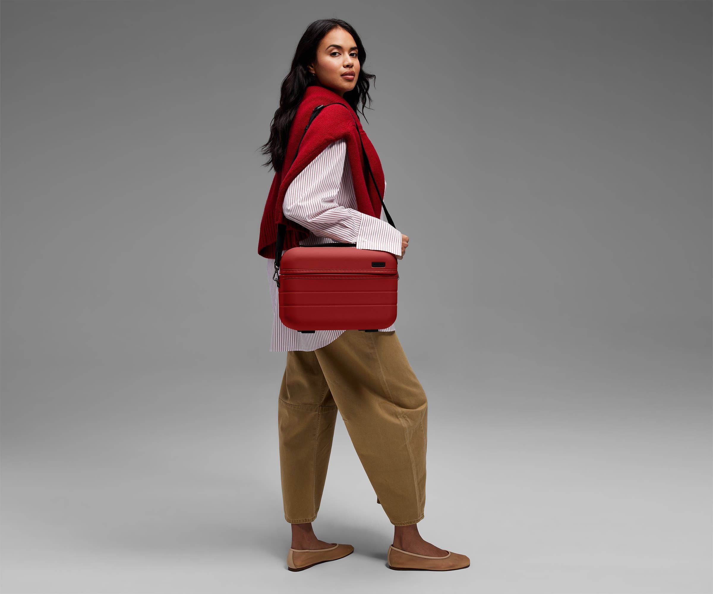 Person wearing the Train Case on their shoulder using the detachable shoulder strap