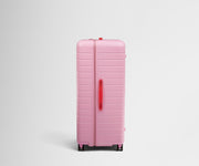 Side product view of The Trunk suitcase in Hot Pink to show the slimmer top lid and deeper main compartment for easy access and packing