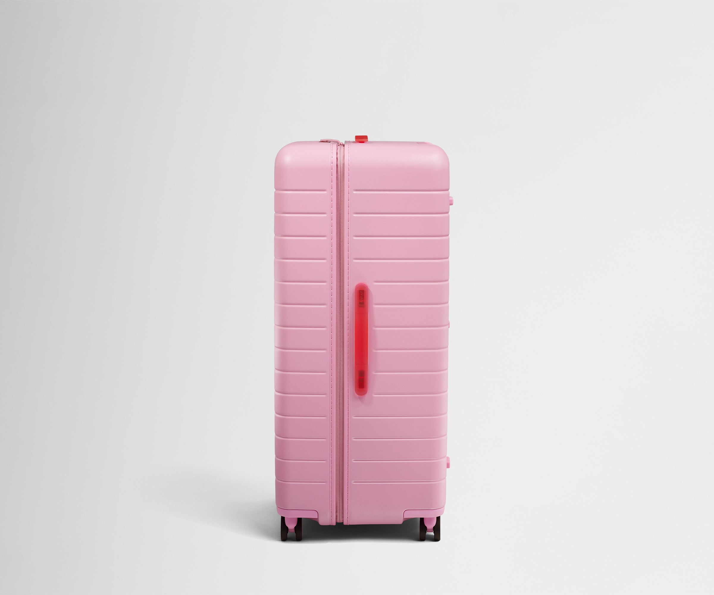Side product view of The Trunk suitcase in Hot Pink to show the slimmer top lid and deeper main compartment for easy access and packing