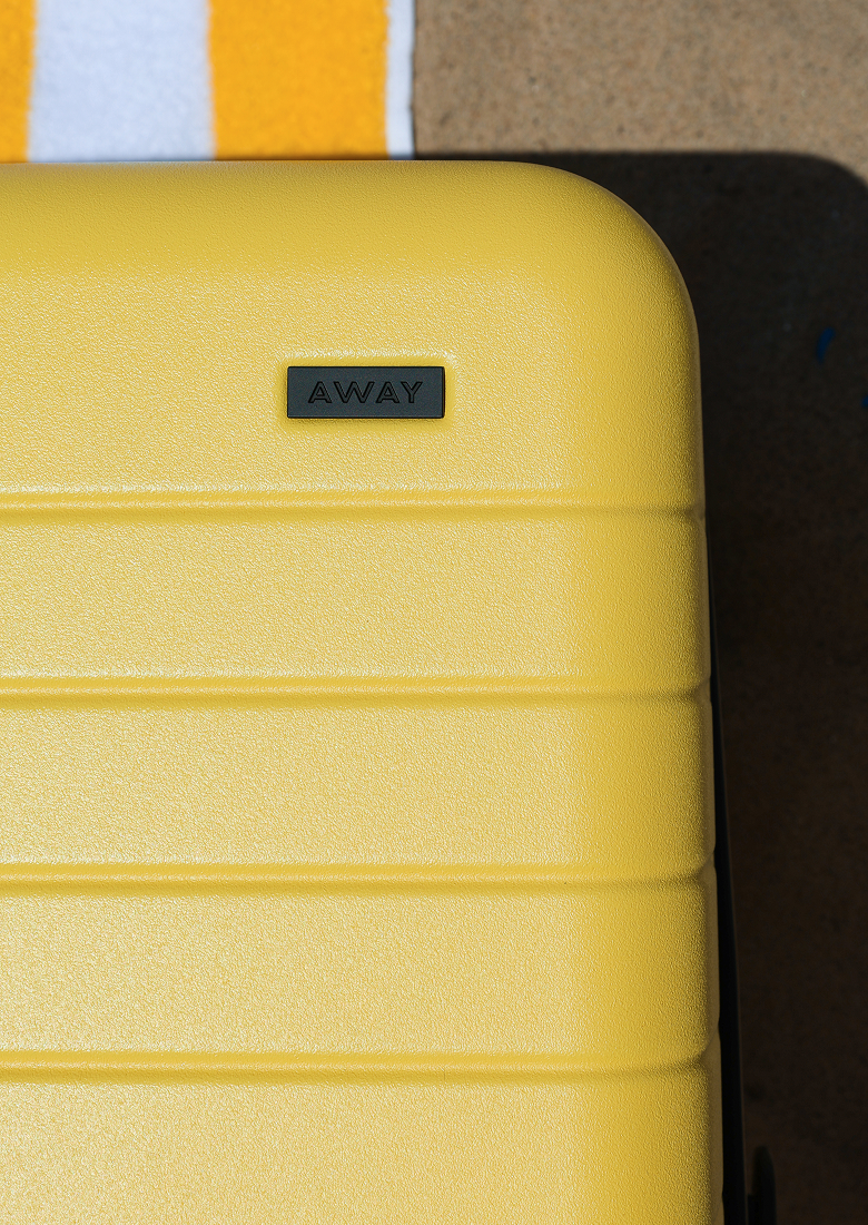 The Bigger Carry-On in Sunshine Yellow in the sun on the beach