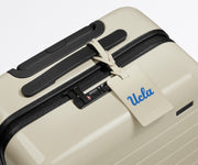 UCLA ® Collegiate Luggage Tag on top of a matching UCLA ® Collegiate Bigger Carry-On suitcase