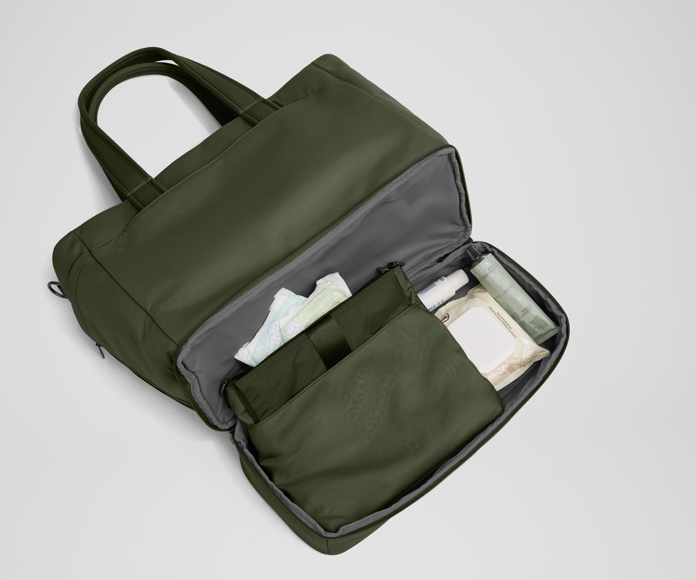 Bottom compartment shown with the included changing pad and Carry-All pouch that fits diapers and wipes