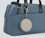 The Circle Zip Pouch looped onto the strap of The Everywhere Bag