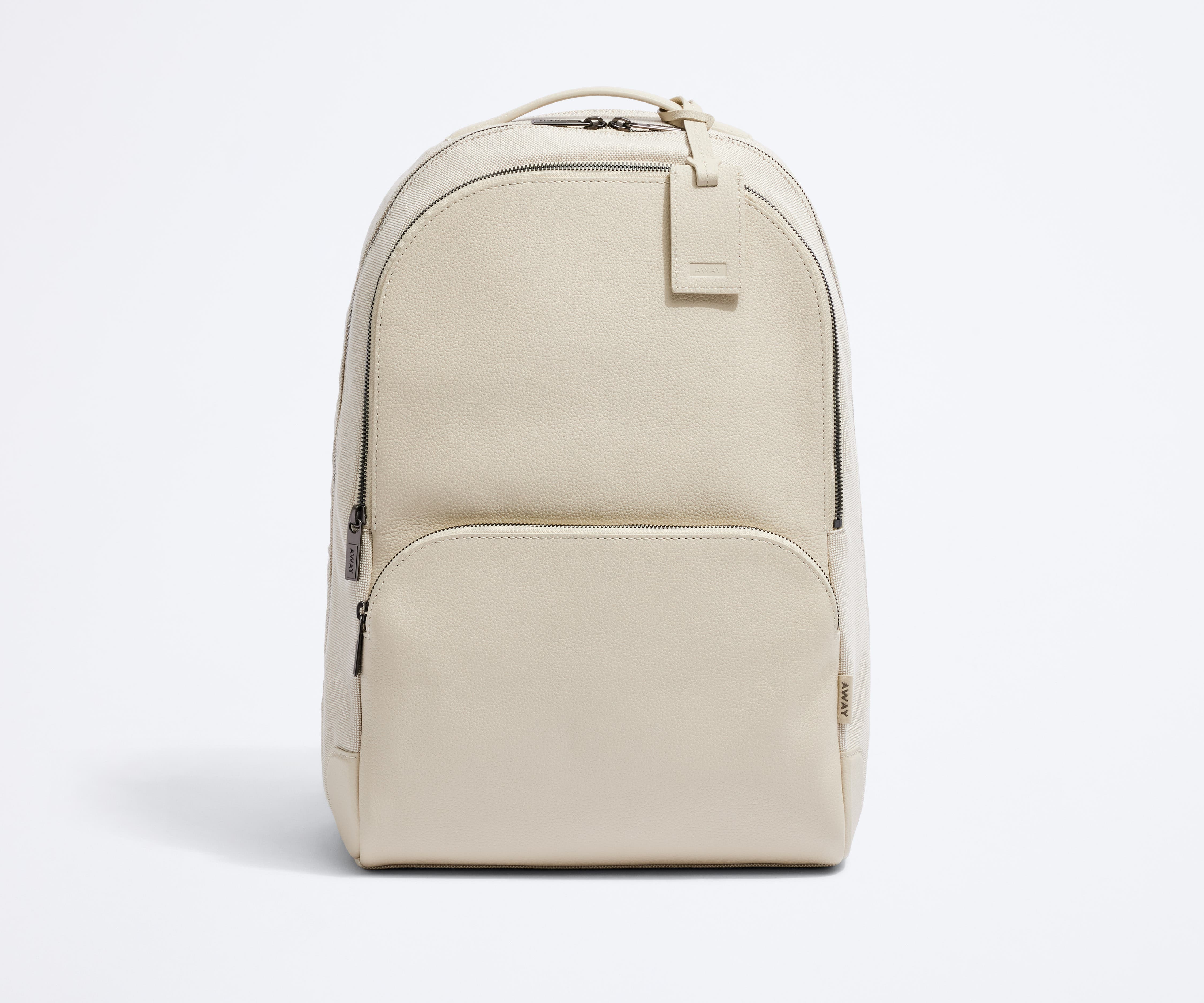 Front view of the Transit Leather Backpack and the dyed-to-match luggage tag