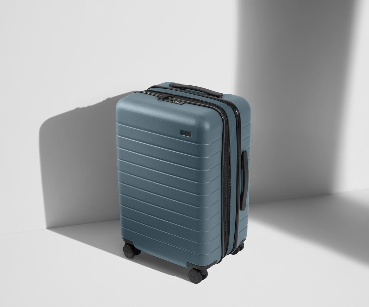 A blue and black rolling hardshell suitcase