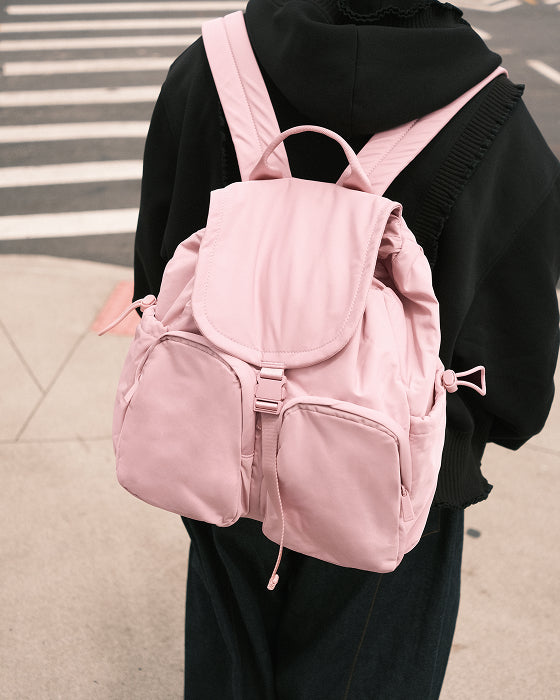 Pink backpack worn by a person on a street