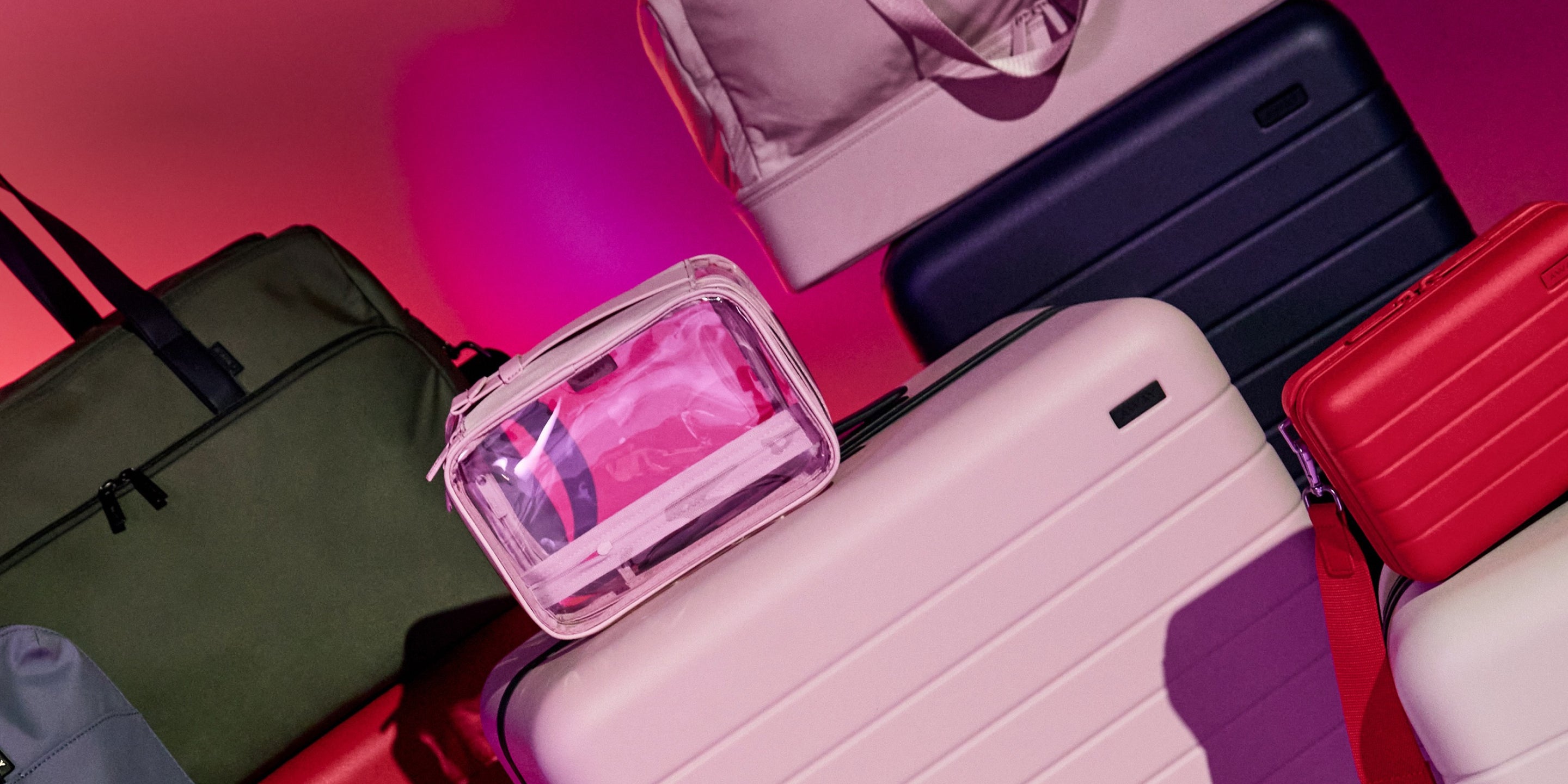 Luggage and travel essentials with a pink gradient background. 