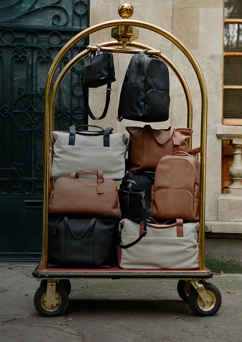 Collection of travel bags on a hotel luggage trolley.
