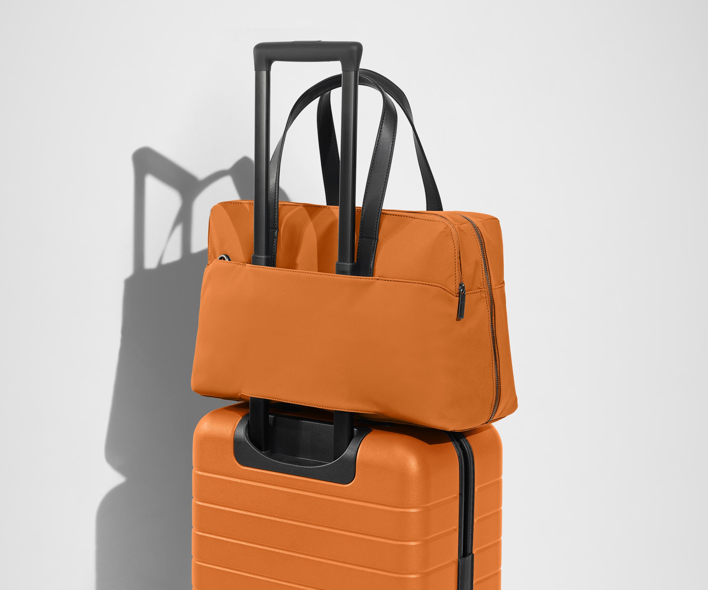 The Everywhere Bag secured to an Away suitcase by its trolley sleeve