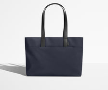 Front view of The Everywhere Tote with its leather handles up