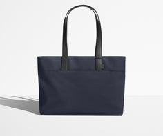 Front view of The Everywhere Tote with its leather handles up