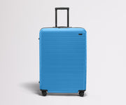 Front product view of The Large Flex suitcase in Splash Blue with raised handle