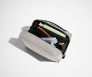 Interior packed with an assortment of toiletries, including tooth paste, tooth brush, and hair brush