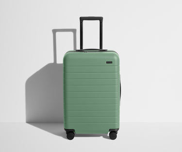 Front product view of The Bigger Carry-On suitcase in Sea Green with raised handle